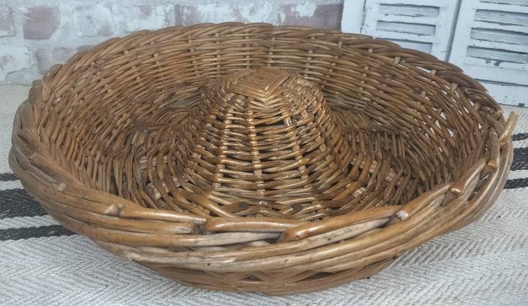 Vintage French Boulangerie bread proving basket made of handwoven wicker with cone-shaped center for rustic loaf rising.