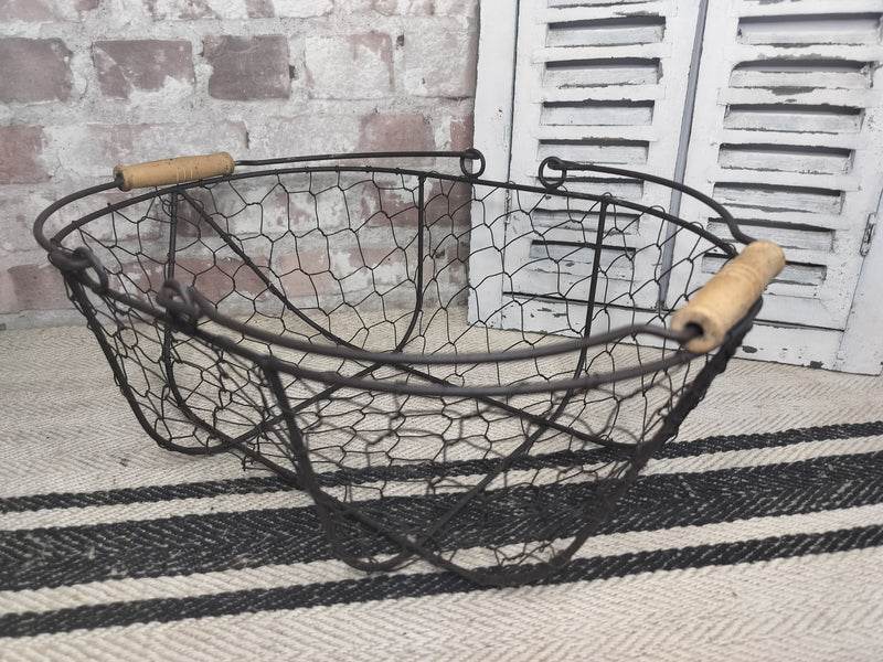 Vintage French picking basket with wire mesh and wooden handles, rustic farmhouse style.