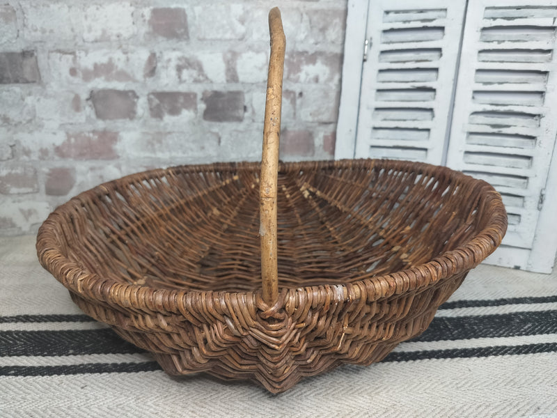 Vintage French wicker basket with woven willow and central handle in rustic brown tones