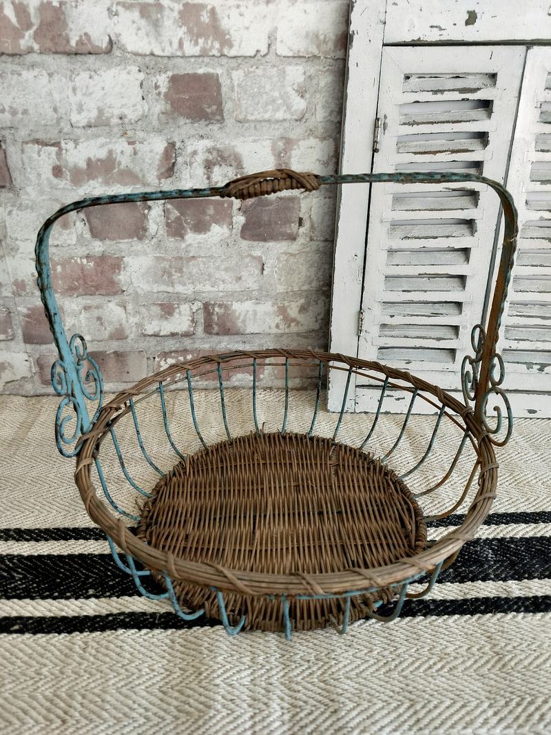 Vintage French blue metal and wicker basket with distressed patina and scrollwork detail.