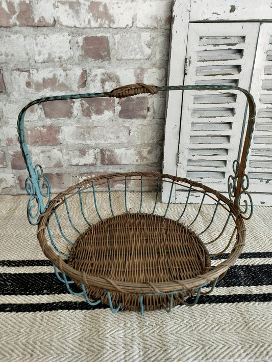 Vintage French blue metal and wicker basket with distressed patina and scrollwork detail.