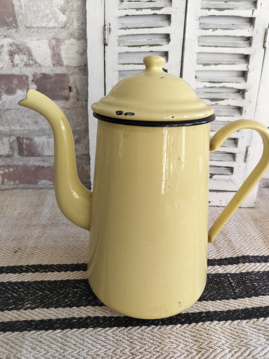 Vintage French enamel coffee pot in yellow with black trim and curved spout.