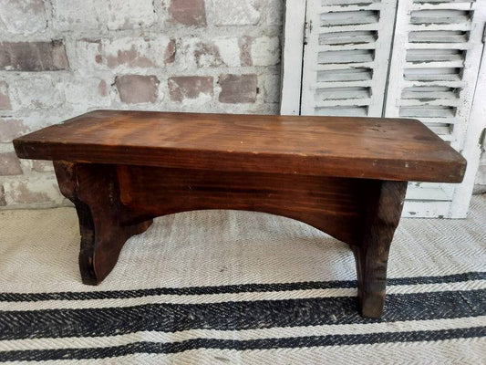 French vintage wooden stool with dark stained finish and arched base, rustic farmhouse style