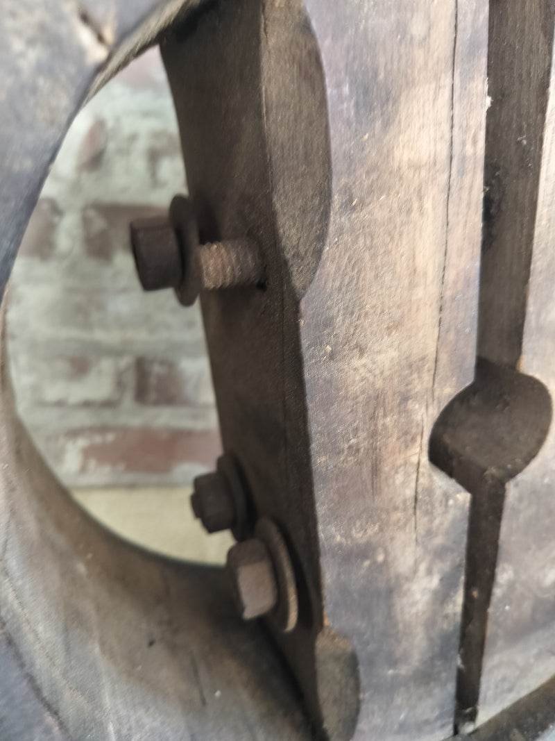 Close-up of antique French wooden pulley wheel with aged wood, iron bolts, and rustic farmhouse decor charm