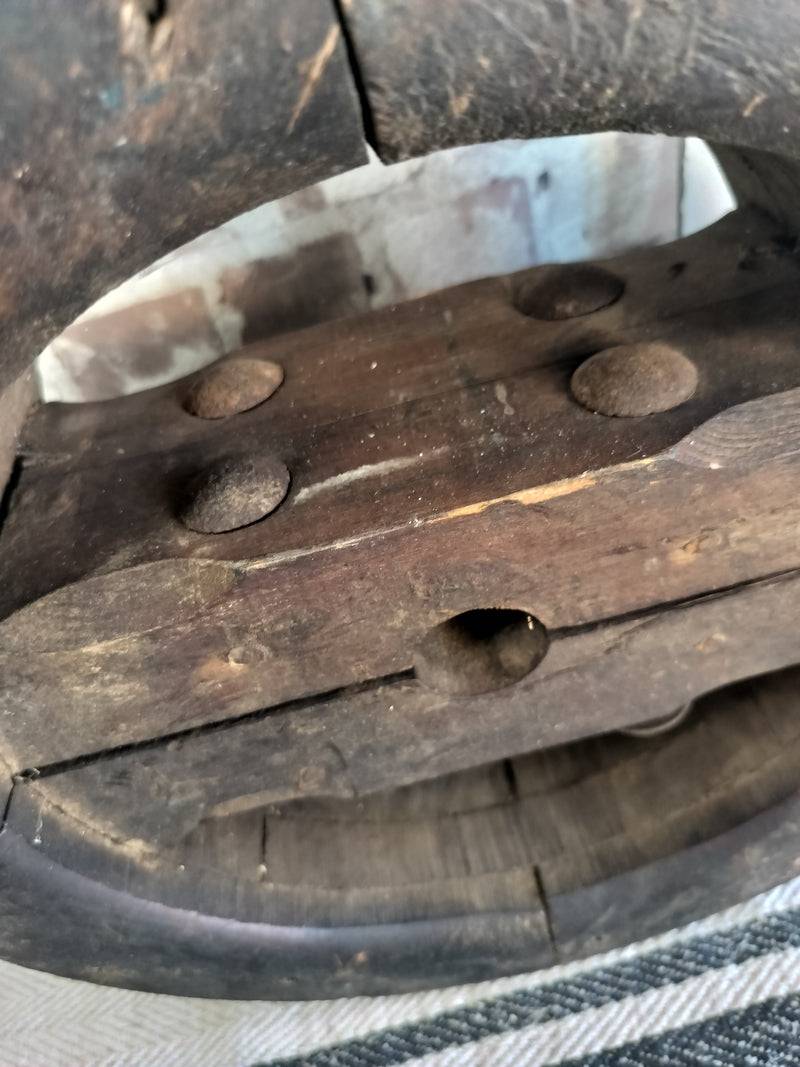 Close-up of Antique French Wooden Pulley Wheel showing aged wood and metal bolts with rustic patina