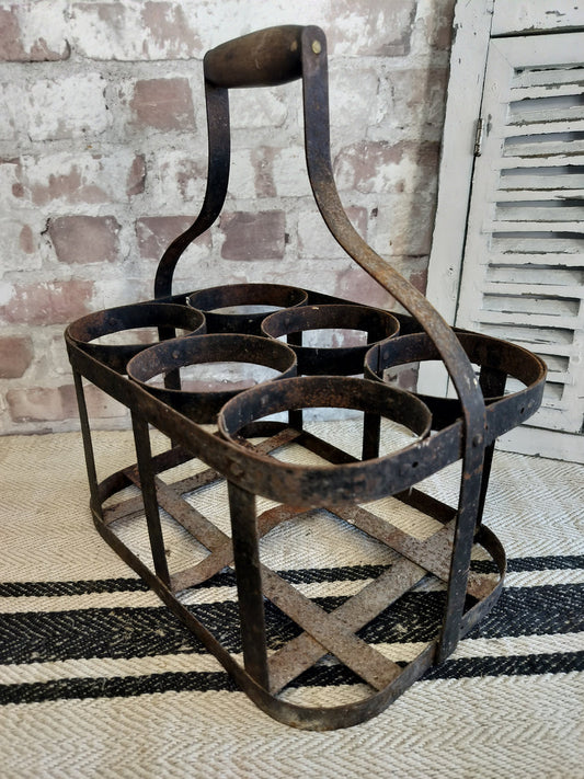Vintage French metal bottle carrier with wooden handle and six bottle slots, rustic aged patina design