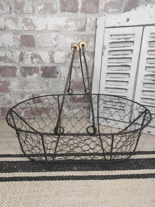 Vintage French picking basket with wire mesh and wooden handles, rustic farmhouse style.