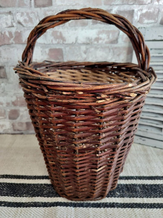 Vintage French tall willow basket handwoven from natural wicker with twisted handle and rustic dark brown finish