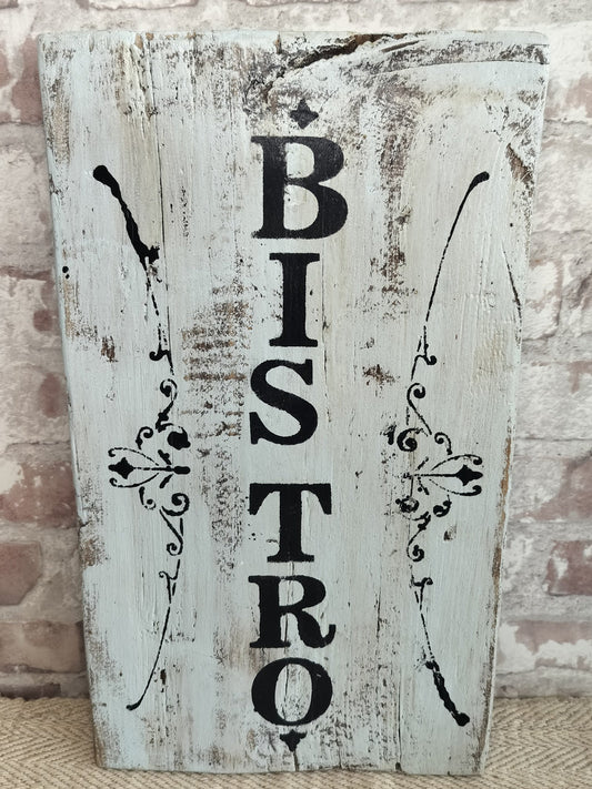 Handmade distressed wooden bistro sign with vertical black lettering and decorative accents on whitewashed wood background
