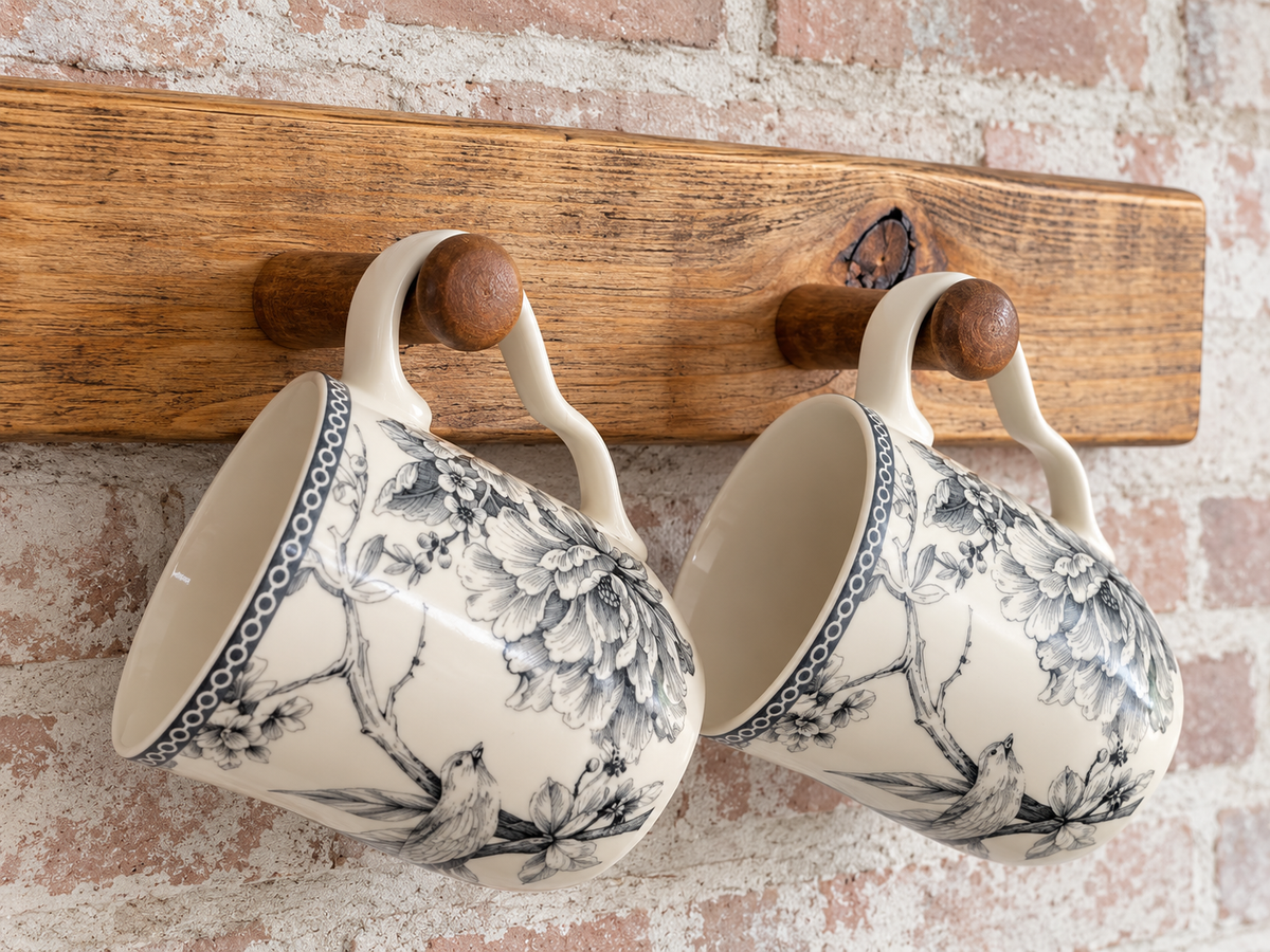 Close-up of handmade solid wood mug rack with wooden pegs and hanging mugs
